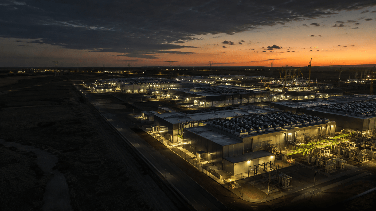Illustrative aerial view of a large modern data-centre campus at dusk